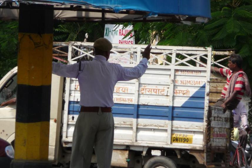 Pour ceux que tant de suspens perturbait trop, ceci est le flic, moustachu même de dos, qui faisait la circulation au rond point du carrefour principal de Lucknow